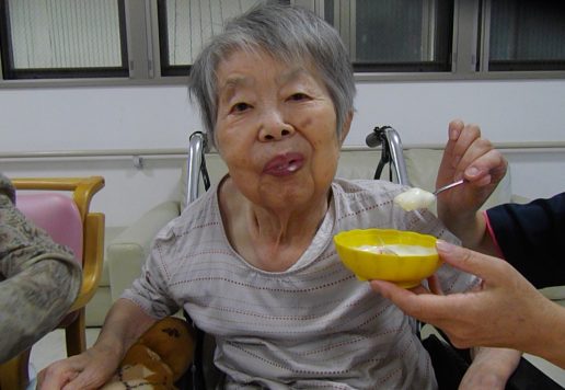 入居者が食事やおやつを楽しむ様子。スタッフがサポートしている生活風景。